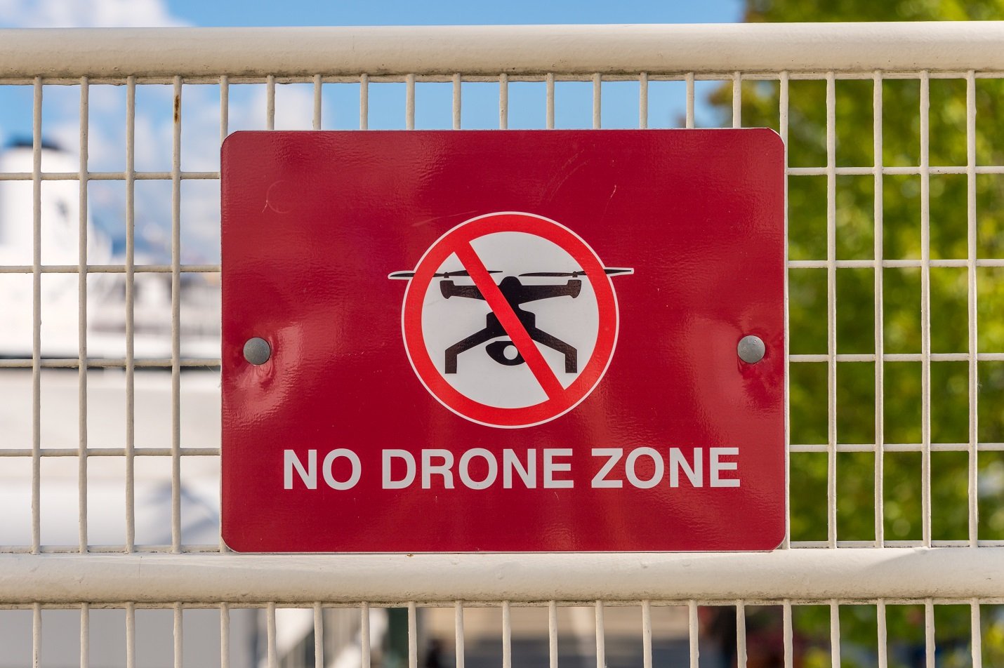 Schild mit Drohnenverbotszone an Zaun 