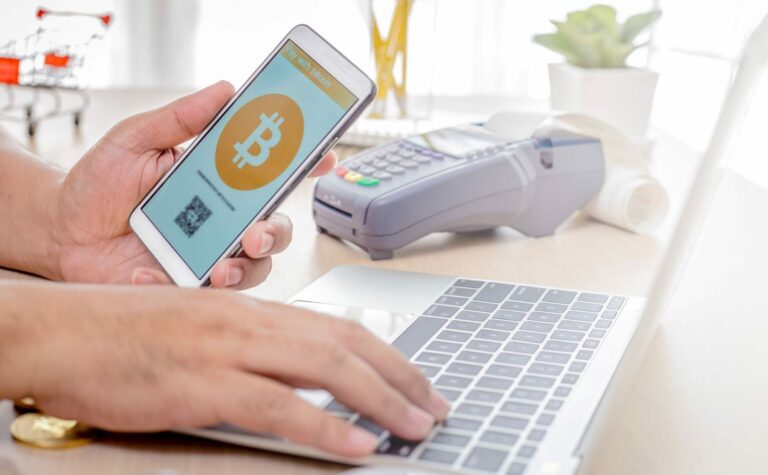 person mit smartphone bezahlt online mit bitcoin
